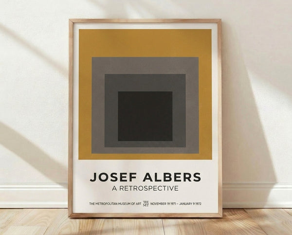 Framed minimalist poster featuring nested squares in mustard gold, warm gray, charcoal, and cream, evoking Bauhaus geometric abstraction and meditative calm.