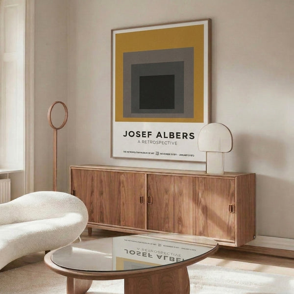 Minimalist framed composition of concentric squares in muted charcoal, warm gray, gold, and cream, expressing timeless Bauhaus aesthetics through pure geometric abstraction.