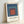 Framed Bauhaus poster displaying stacked squares in navy, burnt orange, and teal against a cream background, embodying geometric harmony and meditative design.