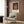 Minimalist poster art featuring overlapping squares in charcoal, terracotta orange, and tan—a study in geometric color harmony displayed framed on a wall.