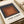 Framed minimalist art showcasing layered squares in muted charcoal, rust brown, and terracotta hues, evoking meditative balance through pure geometric form.