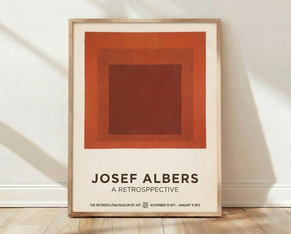 Framed minimalist poster featuring nested squares in rust red, burnt sienna, and cream tones, inspired by Josef Albers' geometric color field compositions.