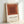 Modern geometric poster showcasing layered squares in earthy rust and cream, exemplifying Albers' contemplative approach to color and form.