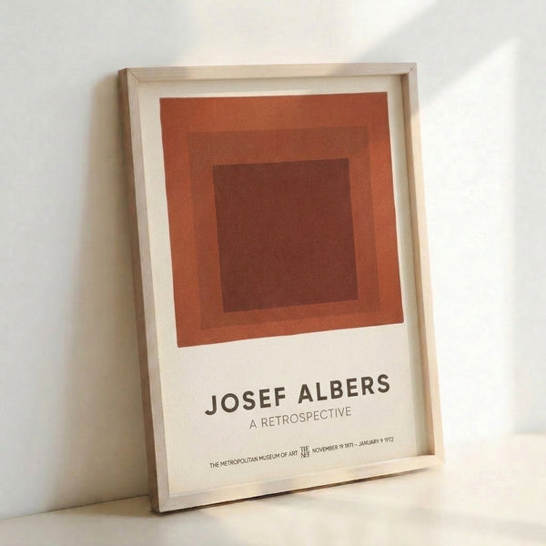 Modern geometric poster showcasing layered squares in earthy rust and cream, exemplifying Albers' contemplative approach to color and form.