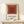 Minimalist framed artwork with nested square shapes in burnt sienna and cream tones, evoking the meditative simplicity of mid-century abstract design.