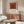 Framed modern poster with concentric geometric squares in cream and deep red hues, reflecting the contemplative essence of minimalist art.