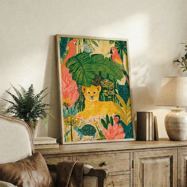 Cottagecore-style framed art print with a vibrant jungle scene of a young lion cub amid exotic animals and botanical elements rendered in forest green, coral red, and creamy yellow hues.