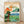 Vintage Japanese woodblock-style travel poster depicting Kirishima volcano rising majestically above a serene landscape with pine forest, temple, and tranquil lake in cream, orange, and deep green tones.