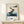 Modern minimalist wall art in watercolor showing stepping stones on a peaceful coastline with charcoal accents, teal water, and a solitary tree in cream and gray hues.