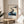 Tranquil Japandi poster art depicting zen stepping stones through calm blue-teal water, rendered in minimalist watercolor with cream, gray, and charcoal for contemplative interior spaces.