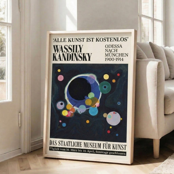 Dark blue and black geometric poster with floating circles and spheres accented by yellow, pink, and teal, reflecting Bauhaus design principles in a framed display.
