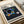 Geometric abstract wall poster presenting a meditative arrangement of circles and spheres in dark blue, black, gold, and pink against a cream field.