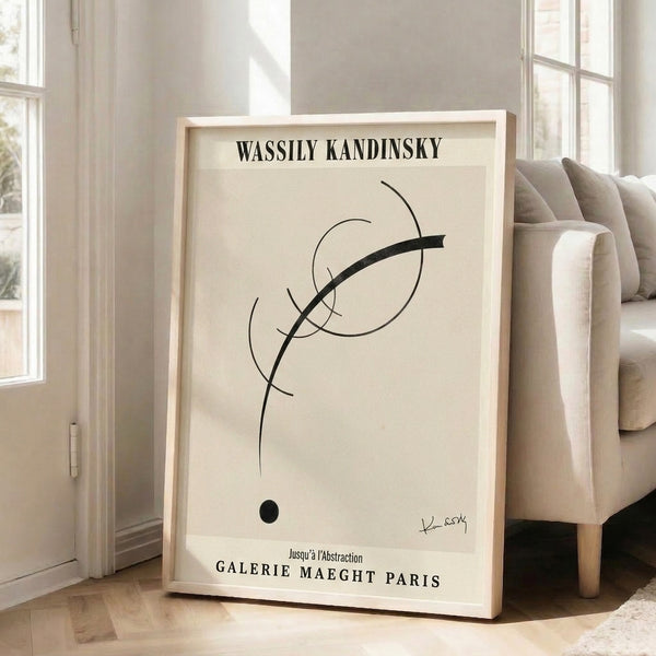Minimalist wall art featuring abstract circles, dots, and intersecting lines in cream and black tones on a framed poster display.