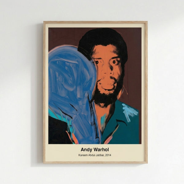 Framed pop art print featuring Kareem Abdul-Jabbar rendered in bright neon colors—yellow, pink, and blue—against a striking black backdrop in the style of Andy Warhol.