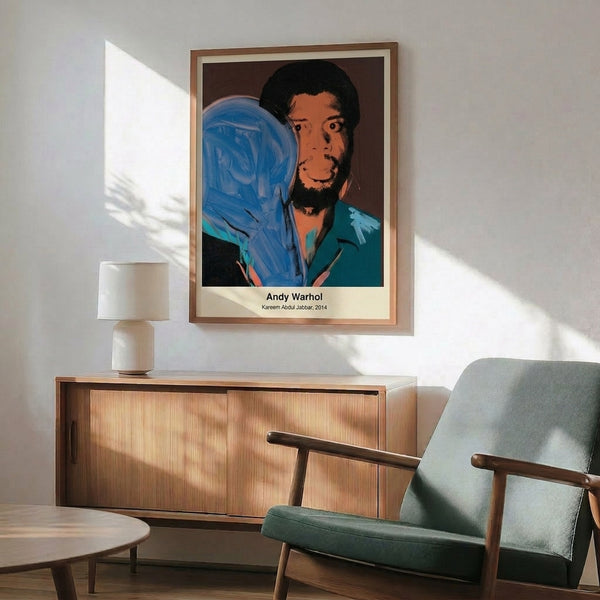 Contemporary pop art wall print depicting Kareem Abdul-Jabbar in vivid color blocks of yellow, bright blue, and hot pink with black definition, echoing Warhol's signature artistic approach.