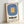 Framed abstract art displaying balanced geometric forms in muted slate blue and warm golden yellow against a cream field, reflecting Bauhaus design principles.