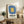 Wall-mounted framed print showcasing Bauhaus-inspired geometric abstraction in cool slate blue, warm golden yellow, and neutral cream palette.