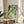 Framed Japanese-inspired koi pond painting showing three graceful fish amid aquatic vegetation in harmonious sage green, cream, and rust color palette.