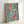 Calming framed poster featuring two koi fish gliding through stylized waves, executed in Japanese woodblock print style with sage green, cream, pale blue, and black accents.