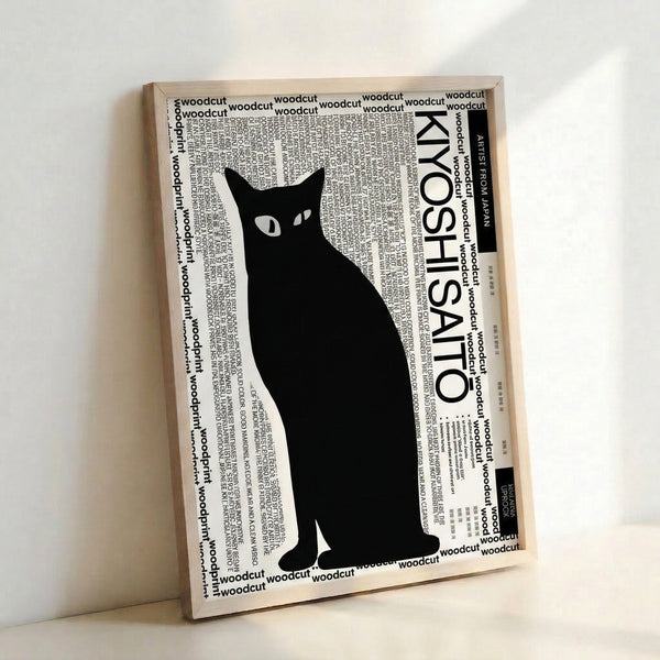 Modern black cat woodcut art with striking simplicity and feline grace, shown framed on an interior wall.