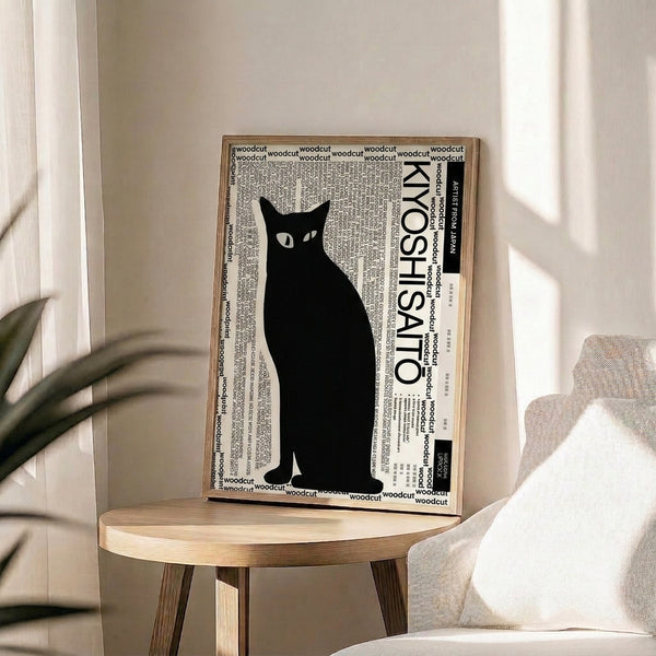Framed minimalist cat print with bold black lines on white, capturing feline elegance through simple, modern woodcut design.
