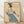 Art Nouveau poster featuring an elegant woman in a cream dress with teal accents, wearing a feathered hat and fur collar, rendered in sophisticated black and rust tones.