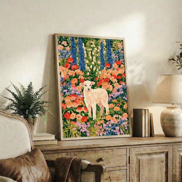 Whimsical nature art print featuring a gentle lamb nestled among blooming wildflowers in warm and cool tones, displayed as a framed wall decoration with joyful cottagecore charm.