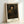 Framed art print depicting a thoughtful male portrait in earth tones and black, with loose impressionistic brushwork and warm lighting that creates a contemplative atmosphere.