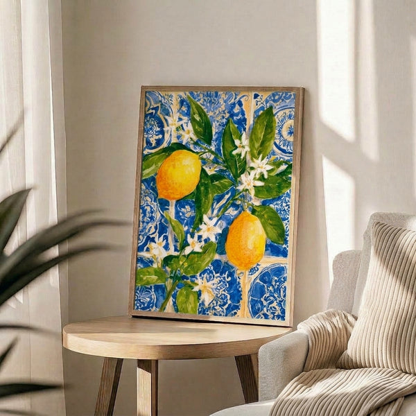 Framed watercolor art print showing fresh yellow lemons with green leaves and cream-colored blossoms against a rich blue geometric tile pattern.