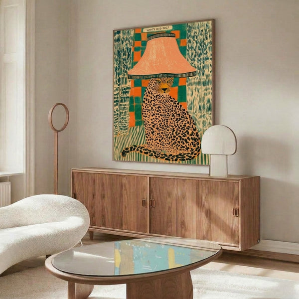 Surreal, playful framed poster depicting a curious leopard peeking around a vintage-style lamp with orange trim, combining retro pop art and folk art aesthetics in cream, teal, and black.
