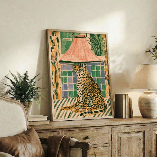 Whimsigoth wall print showcasing a curious leopard peeking from a striped tent with surrounding plants, combining retro illustration style with boho warmth in coral and cream palette.