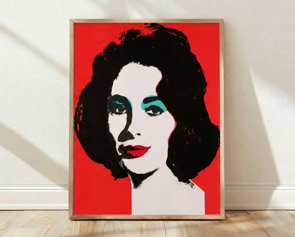 Pop art portrait of Elizabeth Taylor in vibrant colors with bold graphic elements and repeated layered effects, framed on a wall.