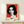 Modern art deco-inspired portrait poster with a woman's face in layered magenta, yellow, and cyan tones, framed on interior wall.