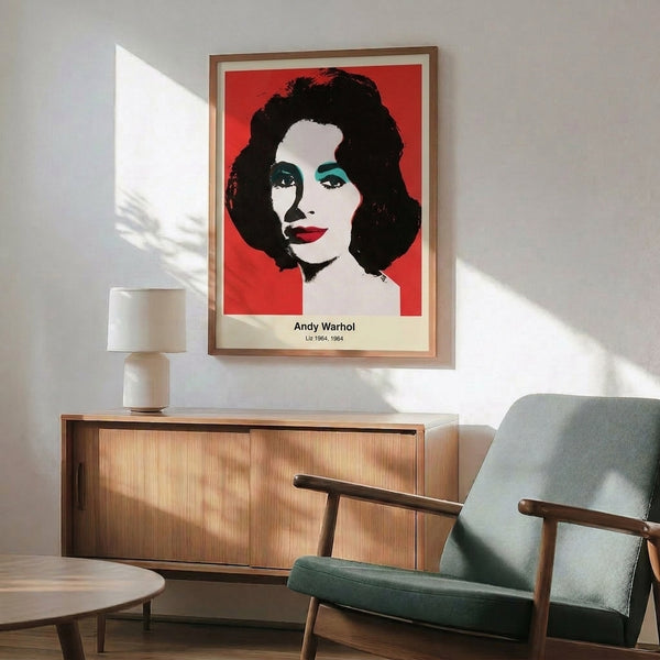 Framed pop art poster showing a female face in bold magenta, cyan, and yellow hues with stark black lines and white space.