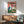 Modern art print on wall showing sophisticated llamas in sunglasses enjoying wine and charcuterie in vibrant pop art style with forest green and burgundy accents.