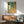 Encouraging vintage-style giraffe print with art deco geometric archway, potted foliage, and a warm palette of teal, coral orange, and cream hues on a wall.