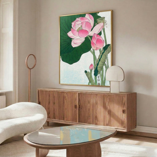 Framed wall art featuring a serene pink lotus blossom amid green stems and foliage, created in Japanese woodblock line art style with warm cream and gold tones.