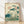 Serene vintage Japanese woodblock-style poster depicting a dragonfly hovering over lotus flowers and leaves in a tranquil pond, rendered in soft cream, teal, pale pink, and sage green tones.