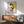 Retro modern art print of a cat rendered through geometric abstraction with a sophisticated palette of cream, black, gray, and vibrant yellow and pink highlights.