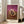 Abstract wall art showing a distorted supine body suspended in negative space, palette of burgundy, cream, and grey creating an unsettling meditative composition.