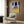 Framed dark modern art poster featuring a fragmented reclining form and its warped mirror image, composed in a palette of ochre, charcoal, and deep tones.