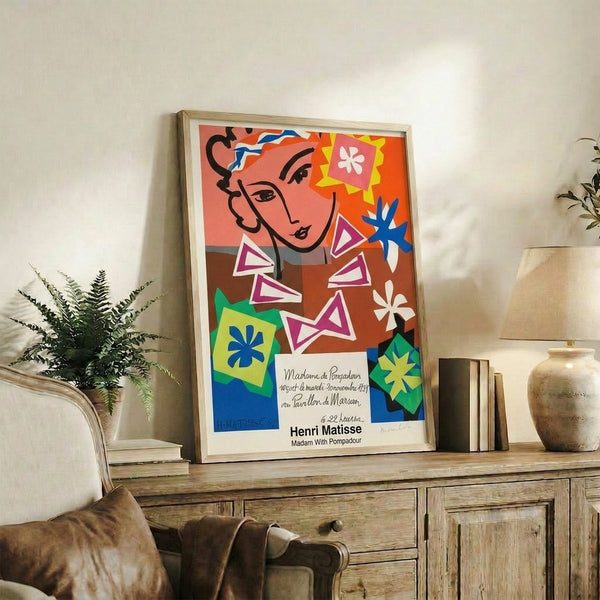 Cut-out style abstract portrait combining warm coral and cool blue tones with ochre accents, a framed minimalist wall print.