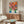 Inventive modernist portrait of a woman's face with pompadour styling in a palette of coral, blue, white, and ochre, wall-mounted as an art print.