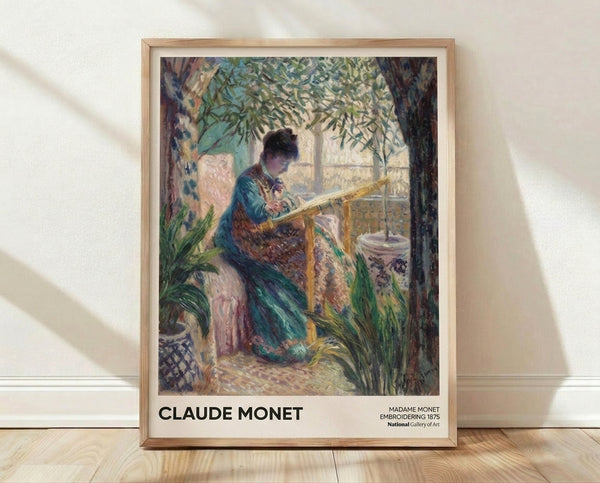 Framed Impressionist painting of a woman in soft blue dress focused on embroidery work near a sunlit window, surrounded by potted plants in warm cream and sage tones.