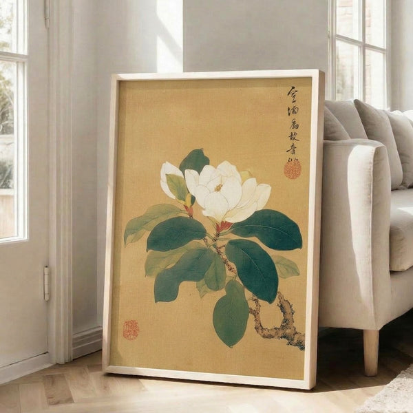 Elegant magnolia flower illustration in soft cream and gold with deep green foliage, executed in traditional Japanese woodblock aesthetic and displayed as a framed poster.