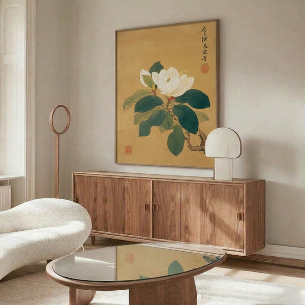 Refined magnolia botanical study with graceful stems and petals in cream and gold accents, featuring deep green leaves in a serene Japanese ink-wash painting style, framed on wall.