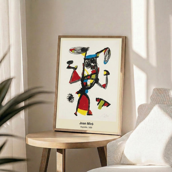 Expressive abstract composition with bold black lines and primary color fills depicting a gestural figure in an energetic, surreal style, presented as a framed modern art print on display.