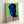 Contemporary pop art interpretation of a figure's face in saturated hues, shown as framed poster in minimalist setting