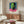 Vibrant pop art face portrait in contrasting hot pink and lime green hues, framed poster showcasing bold modern graphic art aesthetic on wall.