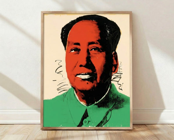 Bold pop art portrait of Mao in vibrant red, yellow, and pink tones with high-contrast graphic style, framed poster on wall.